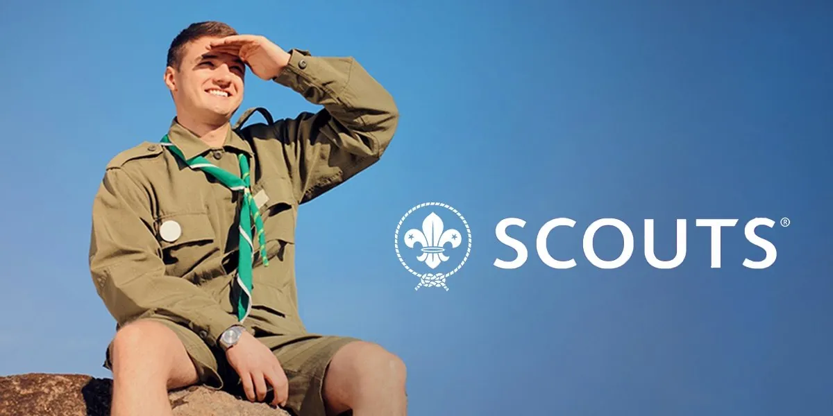 A Scout in uniform looking out over a landscape, with the World Organization of the Scout Movement wordmark