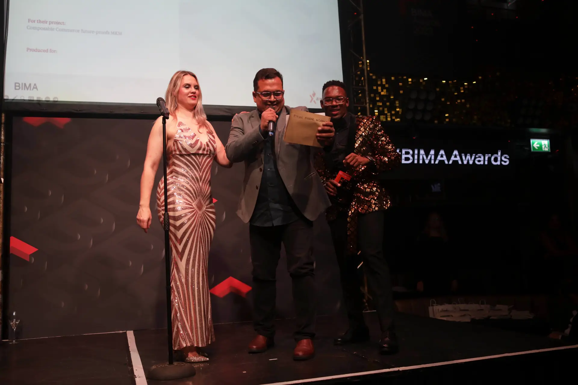 Axelerant team member accepting an award on stage at the BIMA Awards