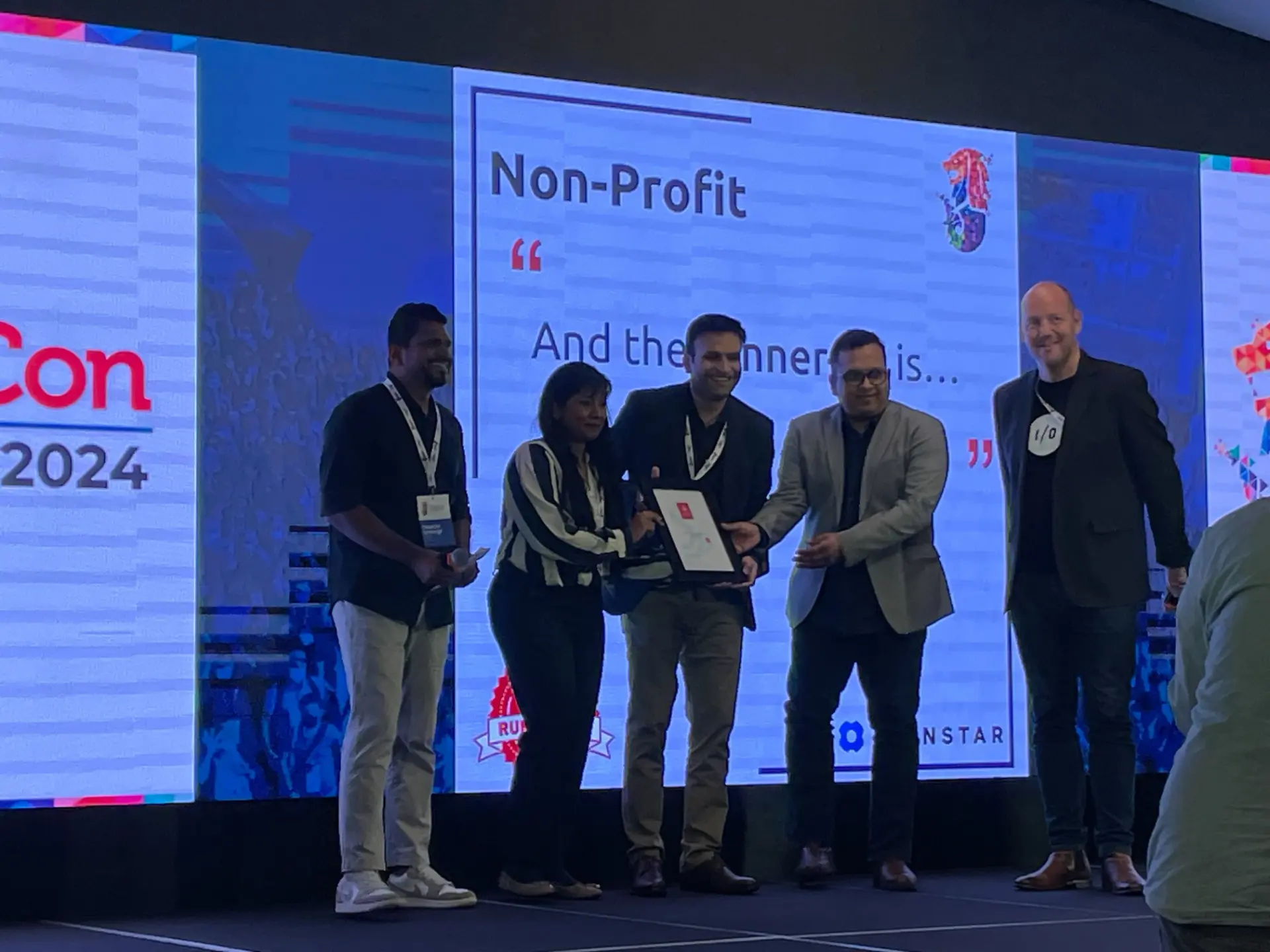 Axelerant team members receiving the Non-Profit award on stage