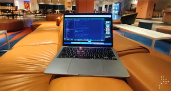 A laptop kept atop a sofa in a cafe