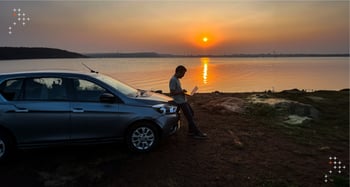 A man working from a lakeside during sunset.